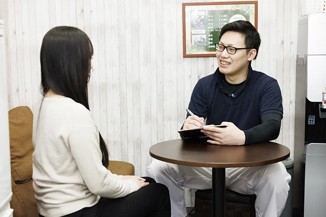 テーブルで来店者とスタッフが相談をしている様子